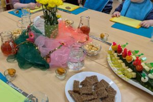 Kinder sitzen an einem gedeckten Tisch zusammen